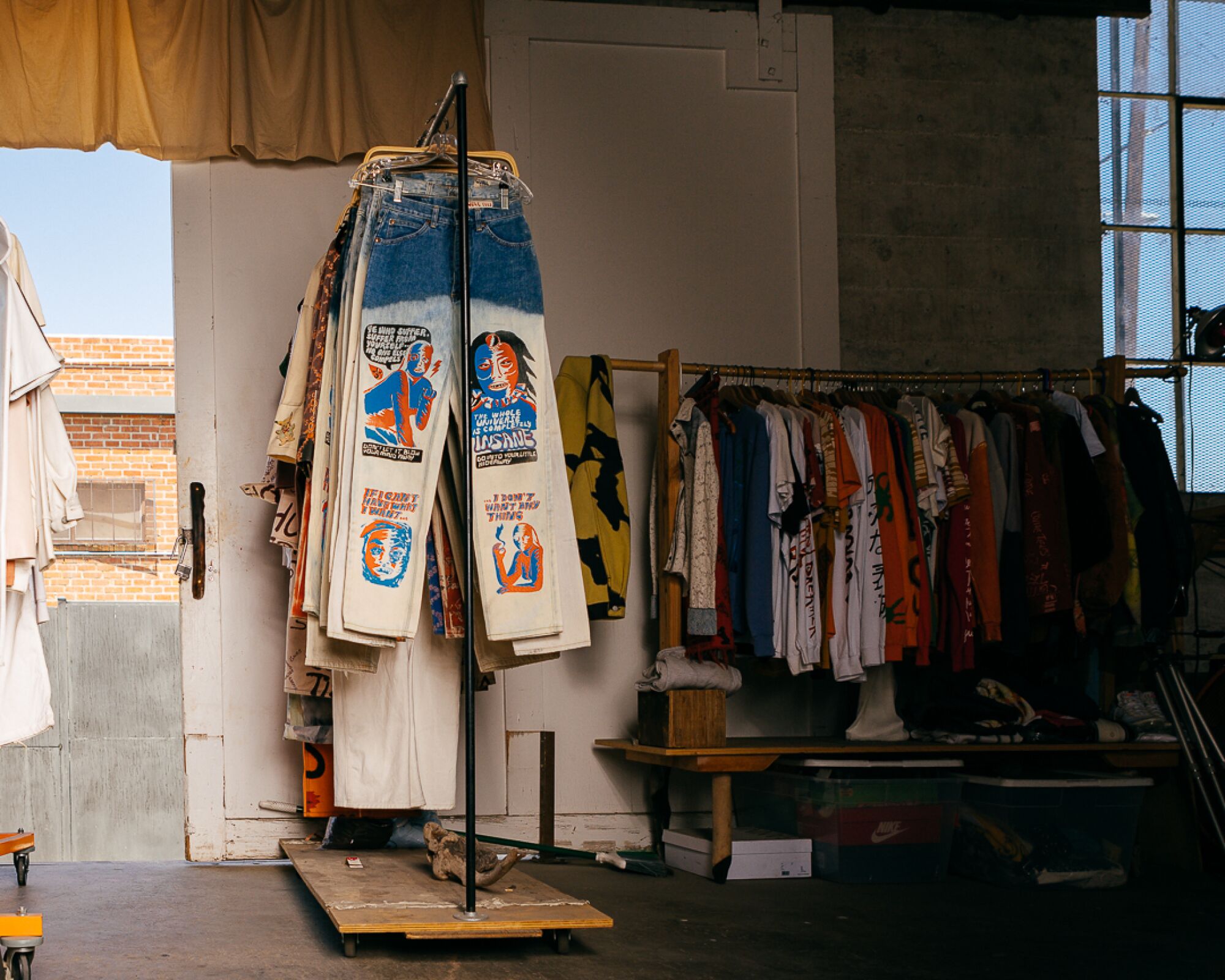 Photo of Come Tees clothes hanging on a rack.