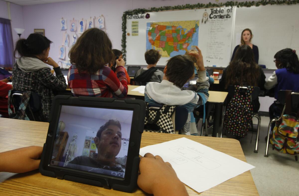 Stephanie McGurk's eighth-grade class at Ocean Charter School turn on their L.A. Unified-distributed iPads this week for the first time.