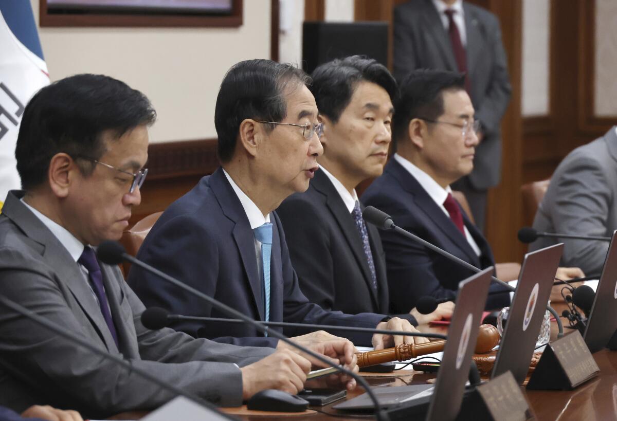 Prime Minster Han Duck-soo sits among a row of four men