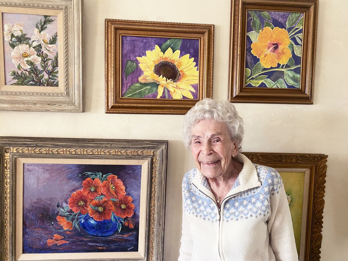 Barbara Bartosik with some of her original oil paintings displayed in her Pacific Beach home.