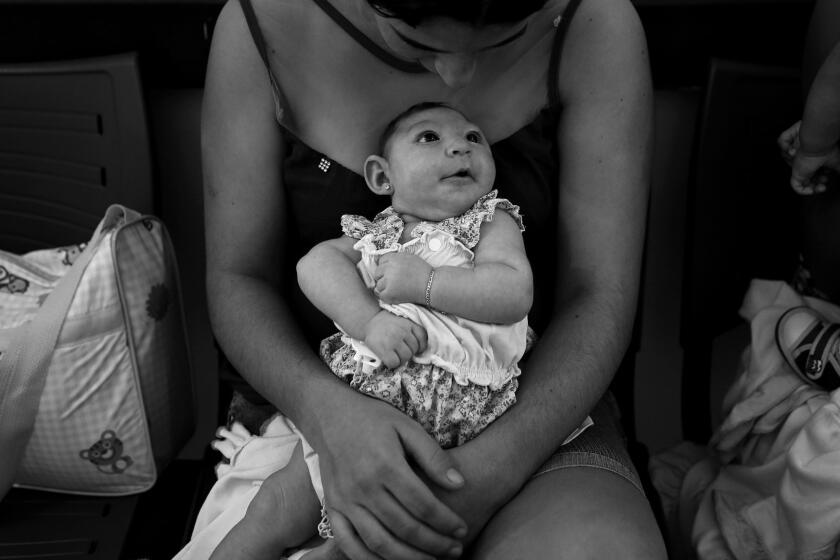 Maria Silva Floa, age 20, holds her baby, Maria Silva Alves, 2 months, who was born with microcephaly, as she waits for her daughterâs physiotherapy appointment at Pedro 1 Municipal Hospital in Campina Grande, Brazil. Maria, along with other mothers of children with microcephaly, bring their babies to physiotherapy appointments two times a week. The type of therapy is thought to help in the development of babies with microcephaly.