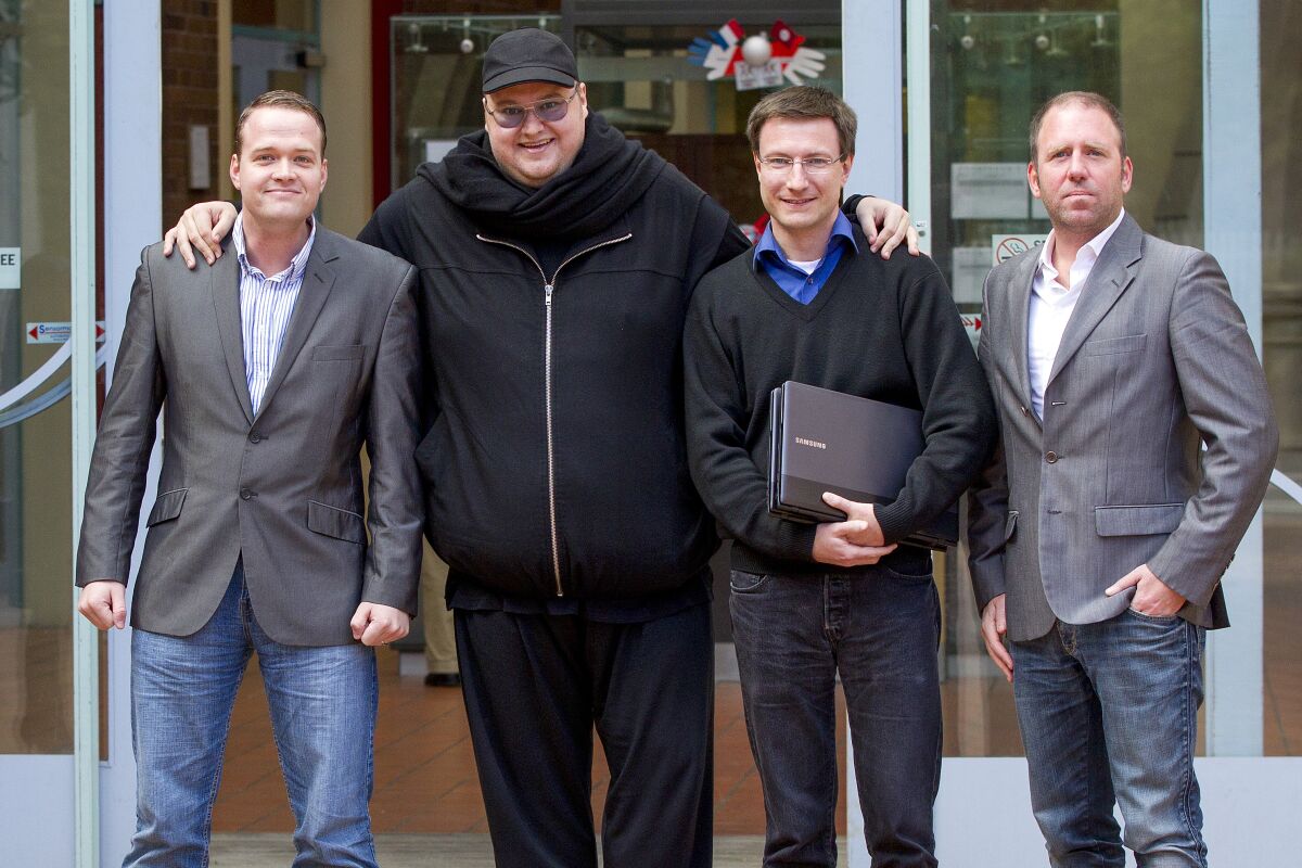 Megaupload founder Kim Dotcom, second left, stands with Bram Van der Kolk, left, Mathias Ortmann and Finn Batato, right, outside the High Court in Auckland, New Zealand, Aug.9, 2012. Ortmann and van der Kolk, charged by U.S. prosecutors with racketeering for their involvement in the once wildly popular file-sharing website Megaupload, said Tuesday, May 10, 2022, that they have reached a deal to avoid extradition to the U.S. and will instead face charges in New Zealand, where they live. (Sarah Ivey/New Zealand Herald via AP)
