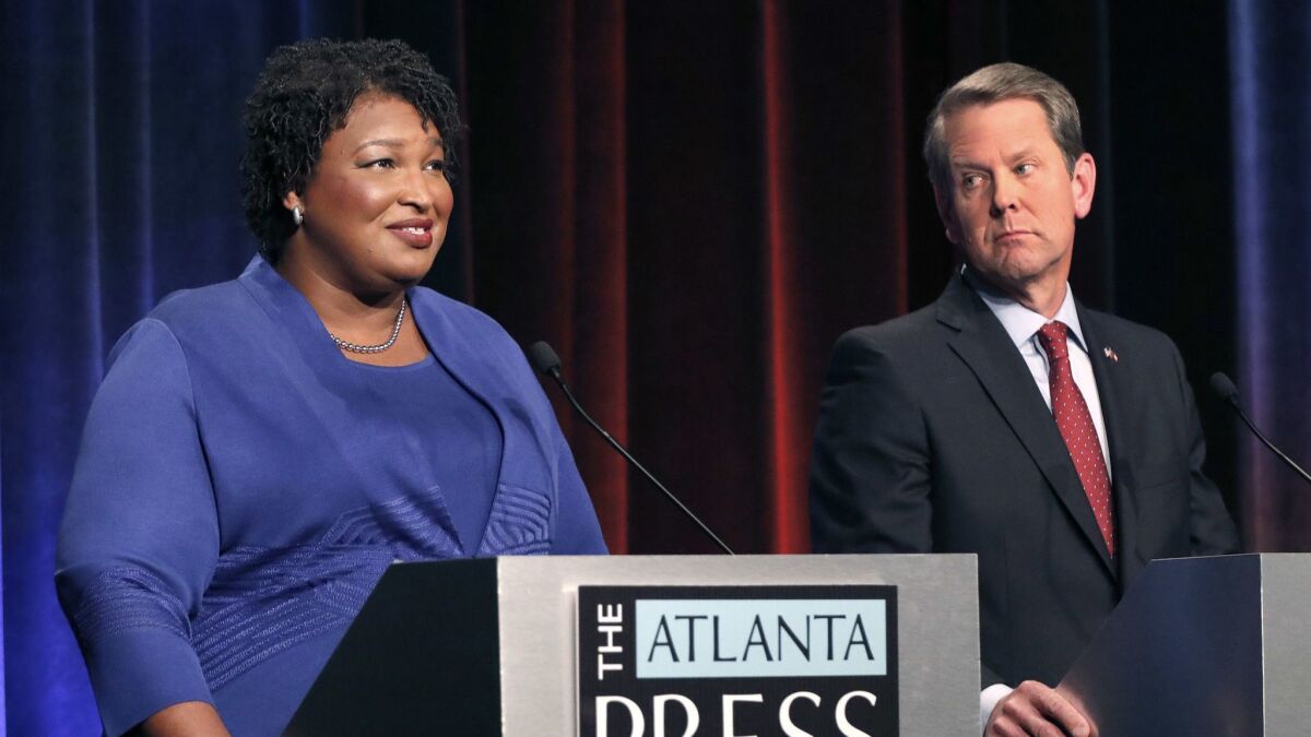 Democratic gubernatorial candidate for Georgia Stacey Abrams, left, speaks as her Republican opponent Secretary of State Brian Kemp looks on during a debate in Atlanta on Tuesday.