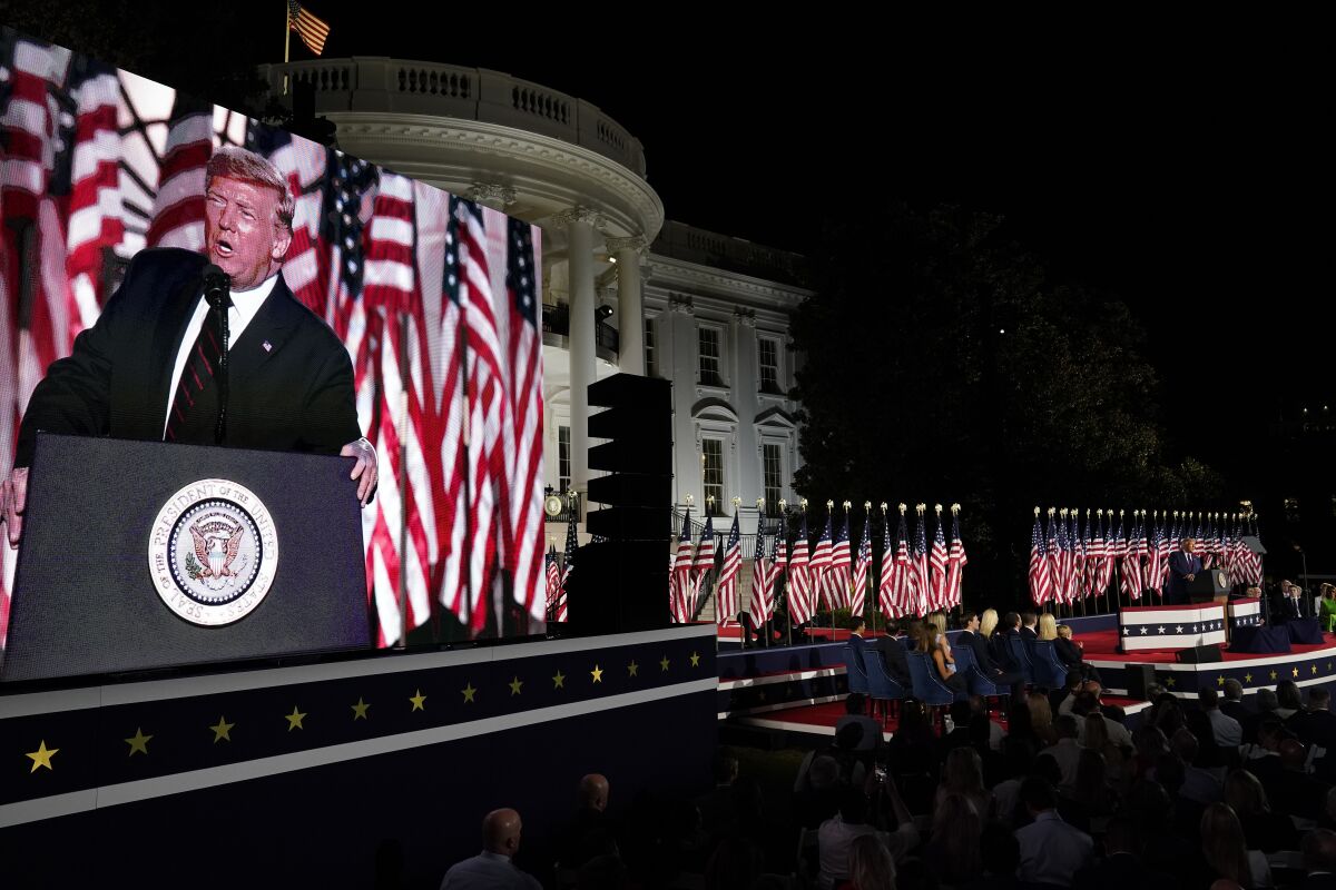President Trump is seen on a large screen speaking from the White House South Lawn during the Republican National Convention.