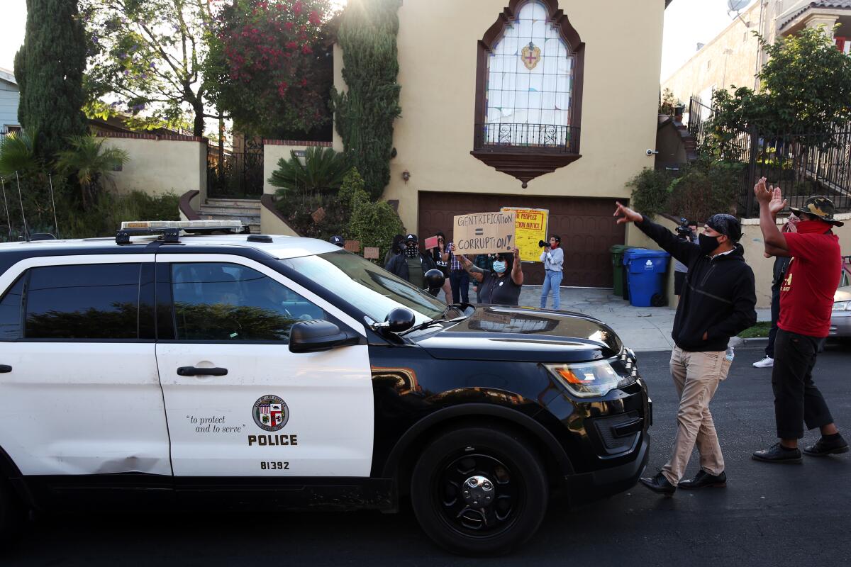 Protestors prevent a police car from passing through while outside Councilman Jose Huizar's home in Boyle Heights