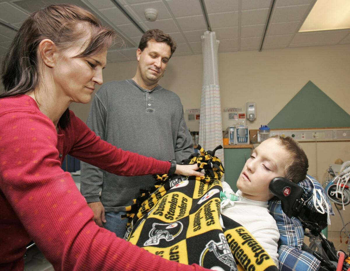 Alex Malarkey, right, with his mother, Beth, and father, Kevin, in his Cleveland hospital room in 2009.