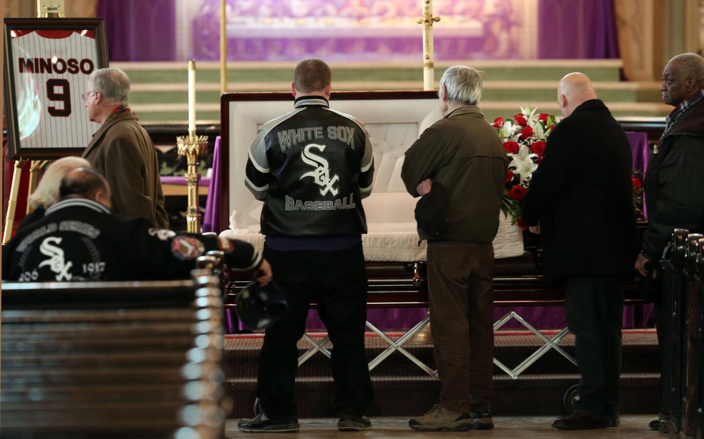 White Sox fan Barry Antoniazzi (Sox jacket) of Bridgeport pays his respects to White Sox legend Minnie Minoso Friday.