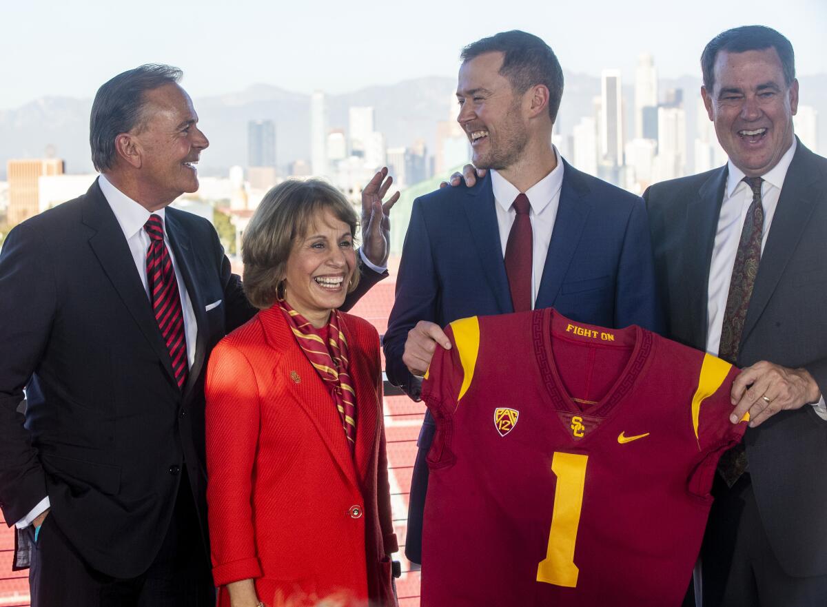 USC football coach Lincoln Riley shares a laugh with USC officials.