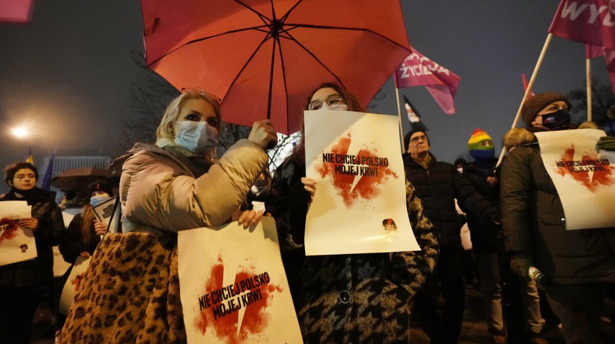 Women held signs saying "Don't ask for my blood, Poland," during a demonstration in front of the Polish parliament in Warsaw, Poland, Dec. 1, 2021. Poland's lawmakers have voted to reject a legislative proposal that would outlaw abortion as homicide and introduce prison sentences for terminating pregnancies. The bill calls for prison terms ranging from 5 to 25 years and in some cases life sentences. (AP Photo/Czarek Sokolowski)