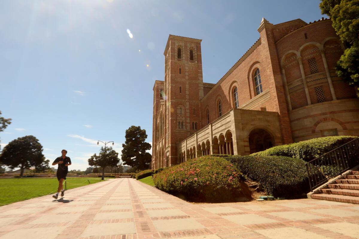 A lone jogger runs past Royce Hall on a nearly empty UCLA campus. 