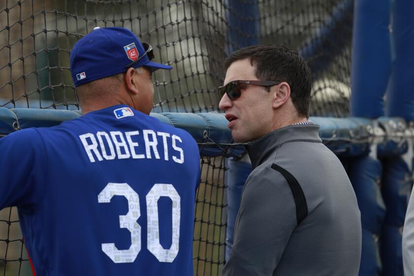 Los Angeles Dodgers President of Baseball Operations Andrew Friedman talks with manager Dave Roberts at their spring training baseball facility Monday, Feb. 19, 2018, in Glendale, Ariz. (AP Photo/Carlos Osorio)