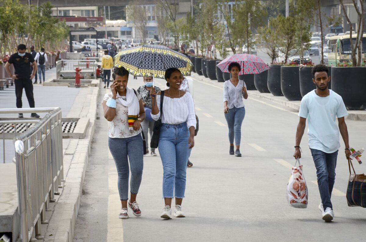 Pedestrians walk along a street in downtown Addis Ababa, Ethiopia Tuesday, Feb. 15, 2022. Ethiopian lawmakers voted Tuesday to end the country's three-month state of emergency, citing recent developments in the conflict, as mediation efforts continue to end the deadly war in the north. (AP Photo)