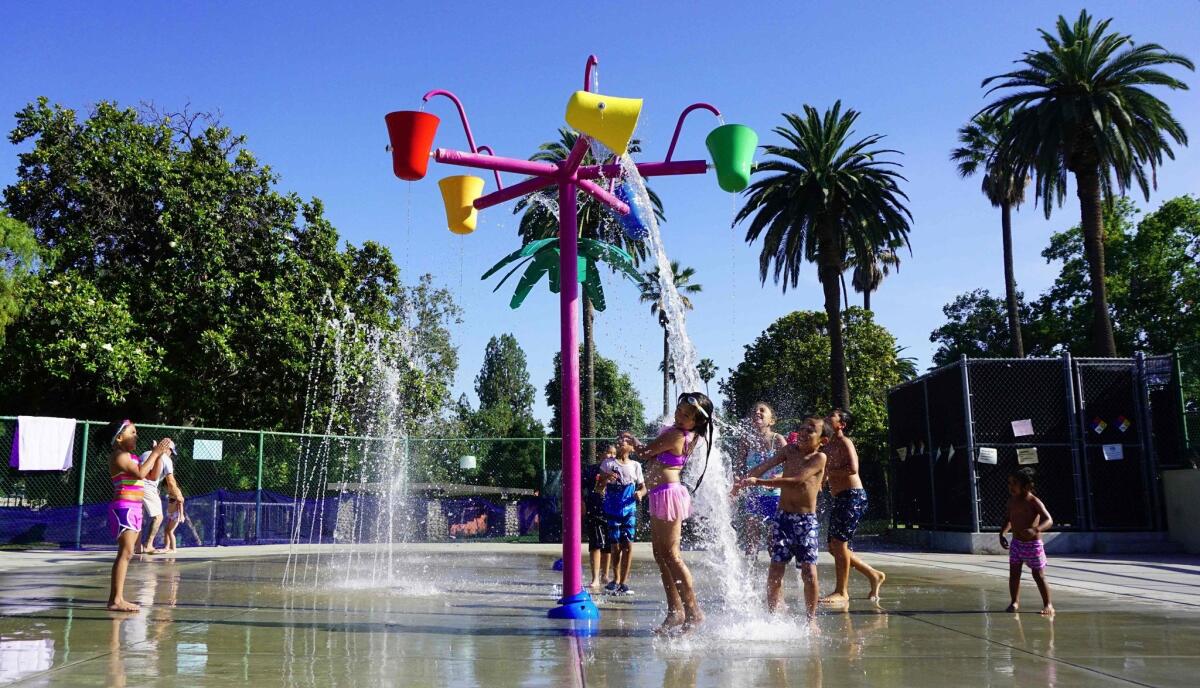 Children cool off at a park in Alhambra, a city with a good location and desirable schools.