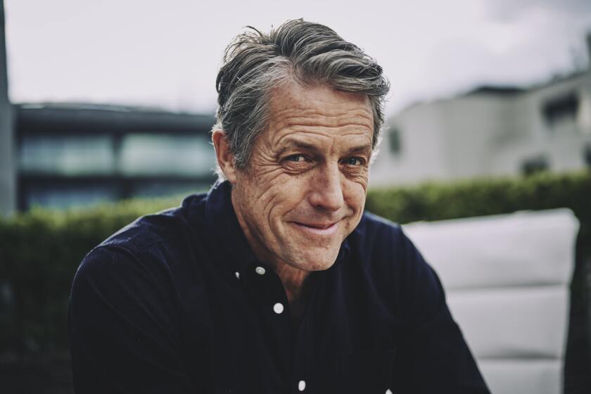 A man posing in a navy blue buttoned shirt