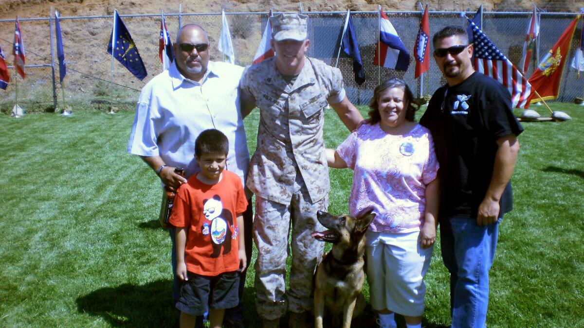 Marine dog Dino with his current handler, Sgt. Jonathan Overland, and relatives of Staff Sgt. Christopher Diaz, Dino's former handler, who was killed in Afghanistan. The Diaz family will take Dino home to El Paso.