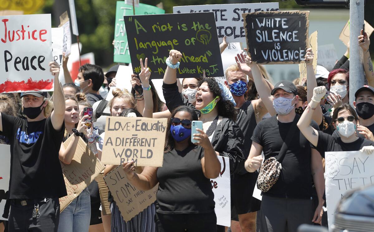 Demonstrators chant and hold up signs during a Black Lives Matter protest in Newport Beach on June 3.