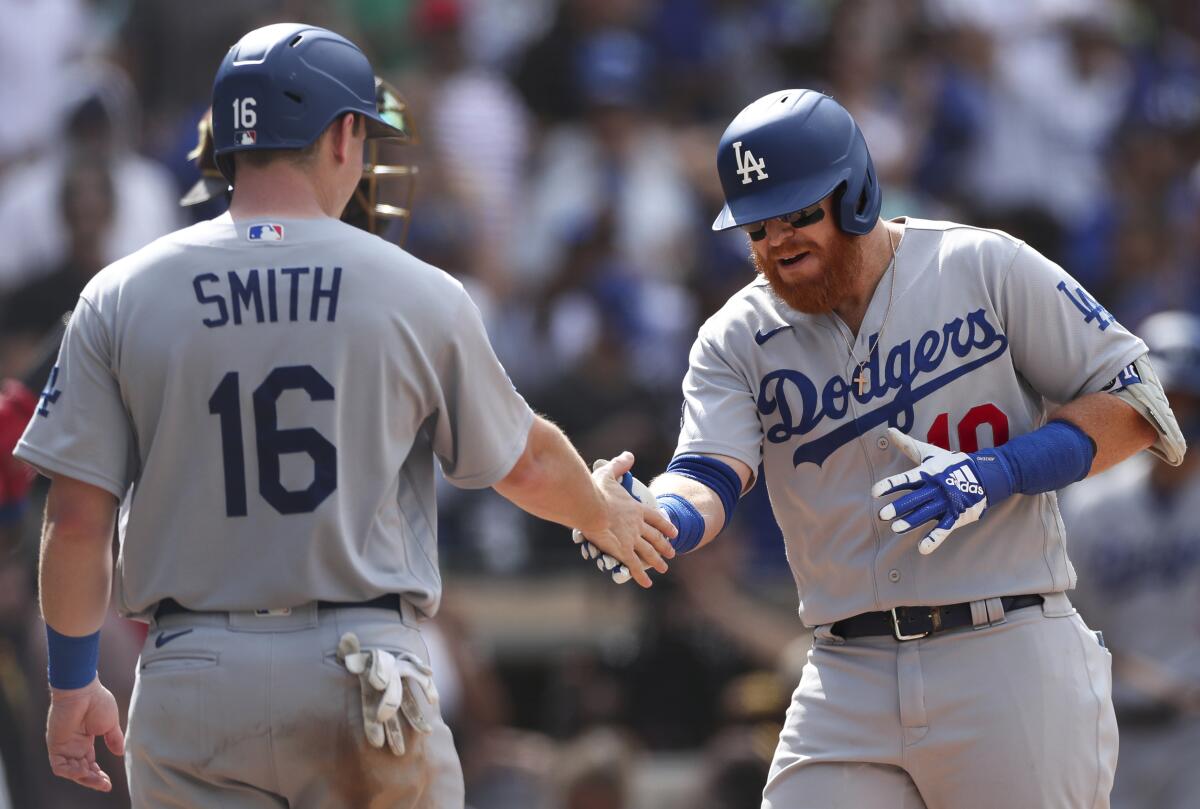 Dodgers' Justin Turner, right, is congratulated by Will Smith after hitting a grand slam against the Padres.