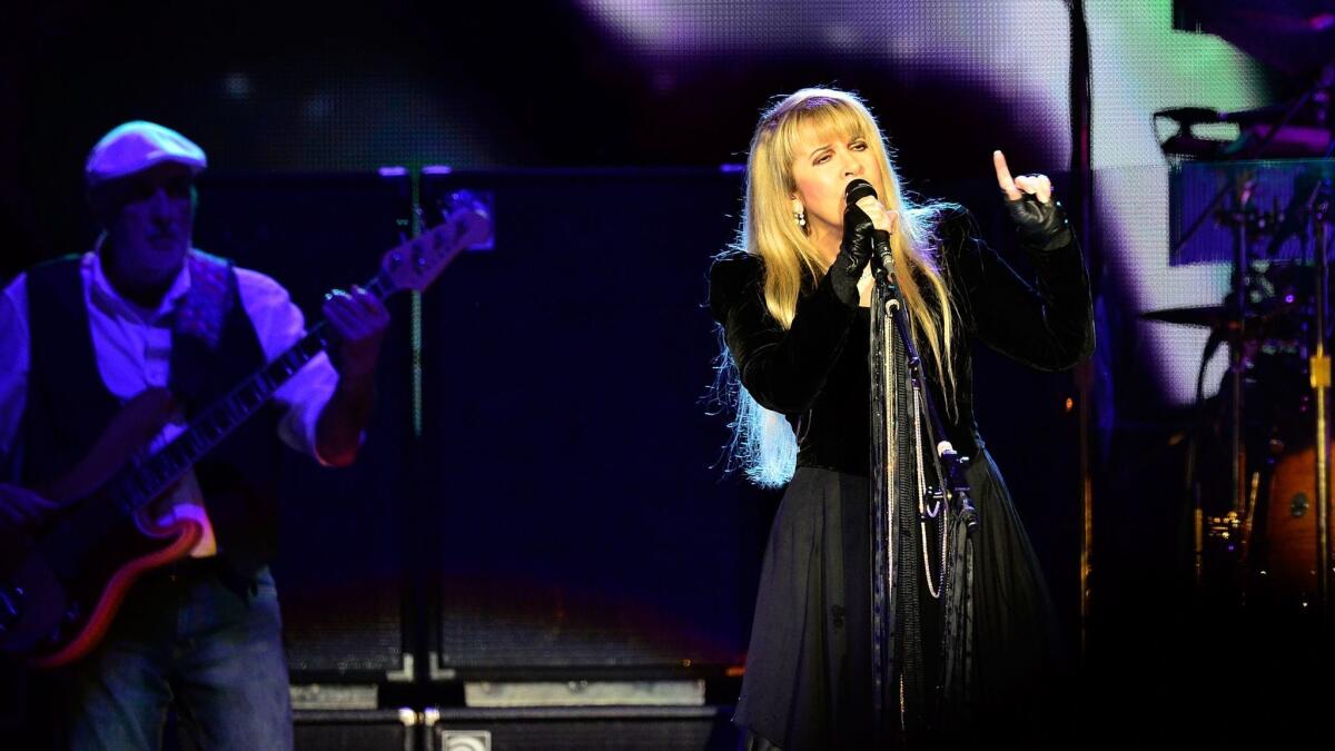 Stevie Nicks performs with Fleetwood Mac in 2013. John McVie is on the right.