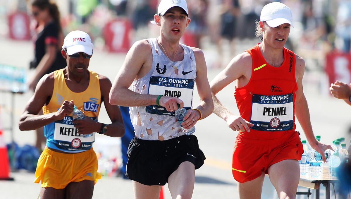 Galen Rupp leads Tyler Pennel and Meb Keflezighi as they pass a water station during the U.S. Olympic men's marathon trials on Saturday.