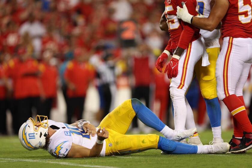 Justin Herbert #10 of the Los Angeles Chargers lays on the ground after being hit against the Kansas City Chiefs