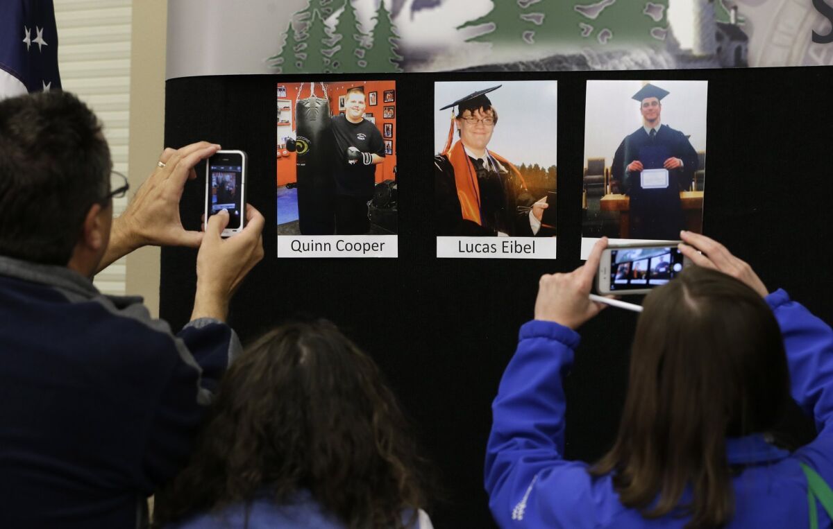 Reporters copy photographs of three of the victims of the mass shooting at Umpqua Community College that were displayed at a news conference, Friday, Oct. 2, 2015, in Roseburg, Ore.
