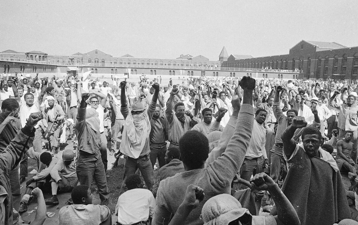 FILE — Inmates at Attica State Prison in Attica, N.Y., raise their hands in clenched fists in a show of unity, Sept. 1971, during the Attica uprising, which took the lives of 43 people. New York authorities have lifted a ban that had stopped state prison inmates from reading a book about the 1971 Attica Correctional Facility uprising following a First Amendment lawsuit brought by its author. (AP Photo, File)