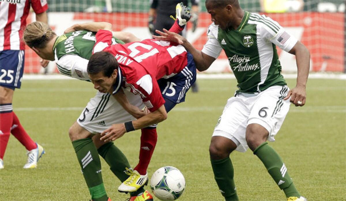 Chivas USA's Eric Avila and Timbers defenders Darlington Nagbe and Michael Harringto battle for the ball during the first half of Portland's 3-0 victory.