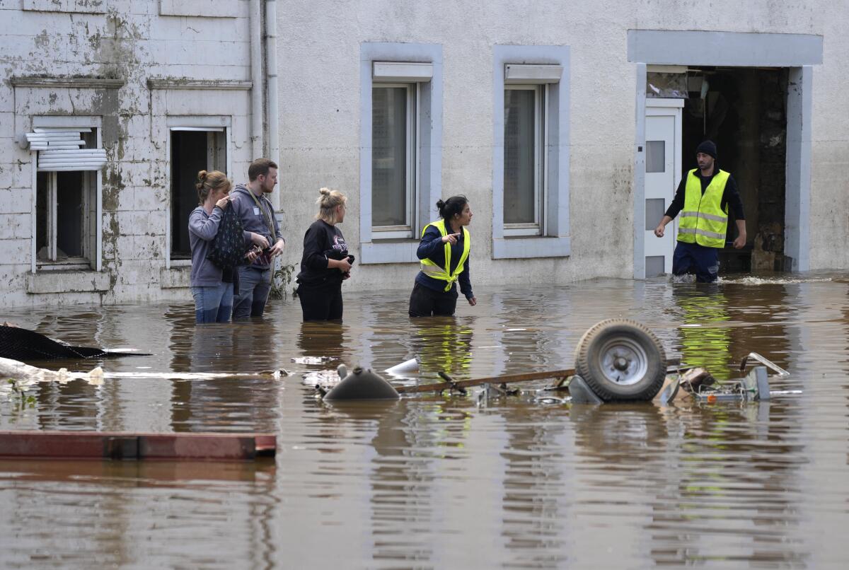 People walk in floodwaters in Pepinster, Belgium