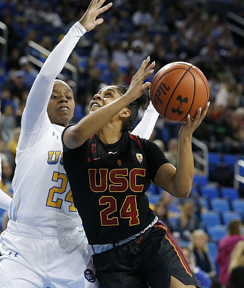 USC guard Desiree Caldwell (24) drives to the basket in front of UCLA guard Japreece Dean (24) during the first half.
