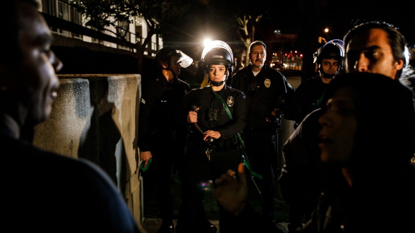 LAPD officers face off with protesters blocking a Homeland Security van in downtown Los Angeles on Thursday night.