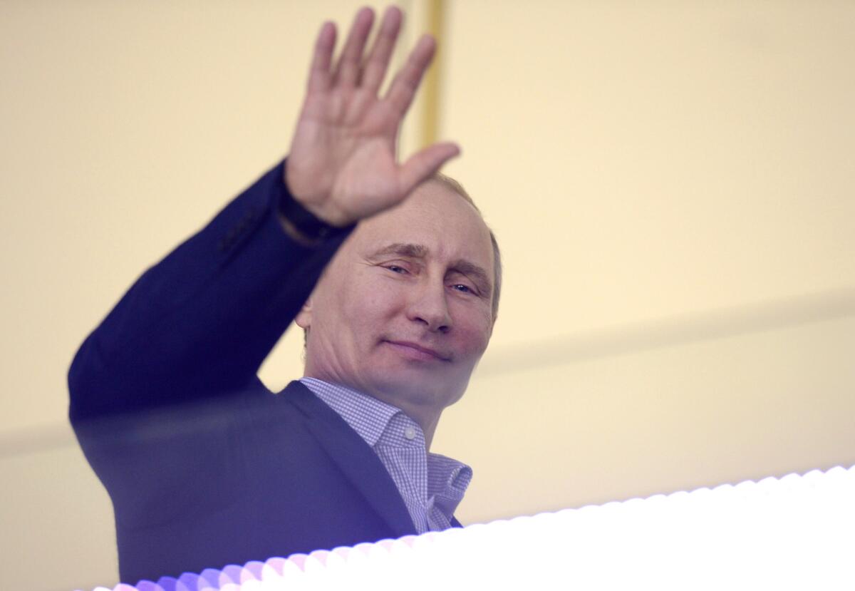 Russian President Vladimir Putin waves during the Men's Ice Hockey Group A match of the USA vs. Russia at the Bolshoy Ice Dome during the Sochi Winter Olympics on February 15, 2014, in Sochi.