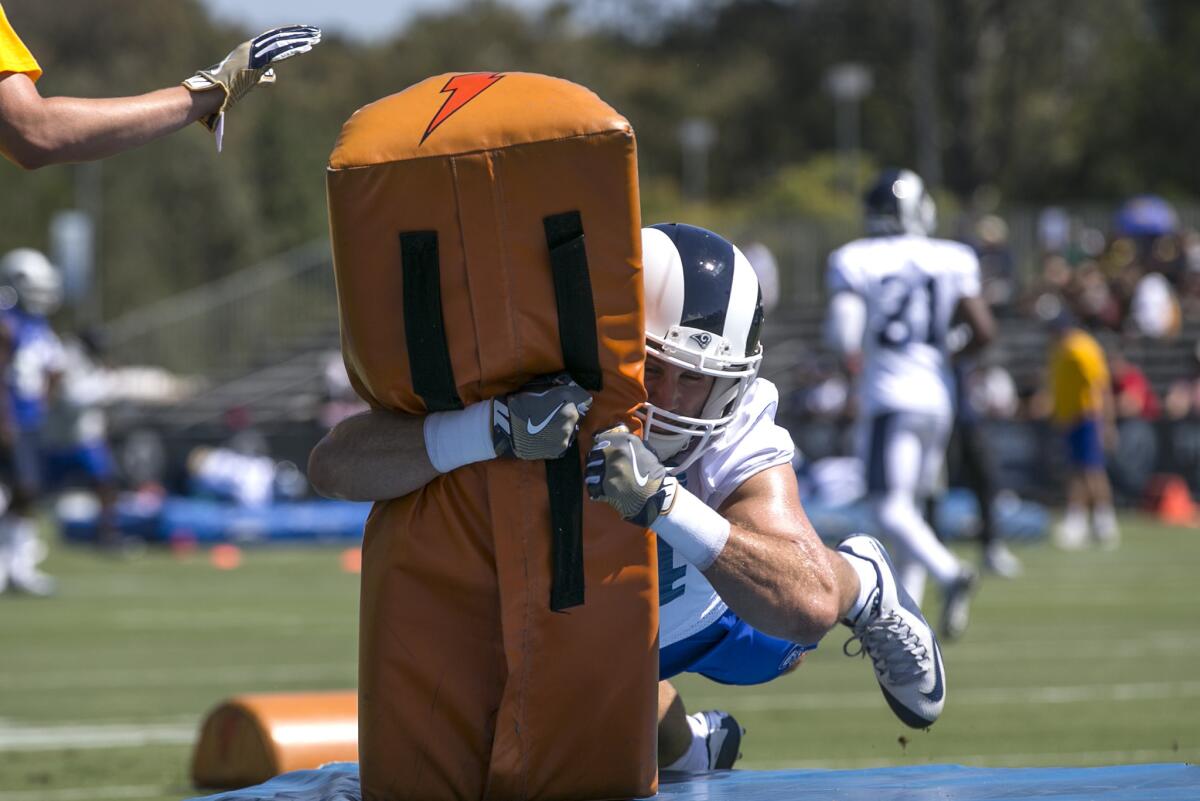 Linebacker Bryce Hager dives into a tackling dummy during special teams drills at Rams training camp.