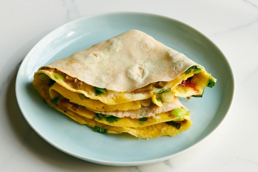 A flour tortilla is folded with egg cooked in the middle.