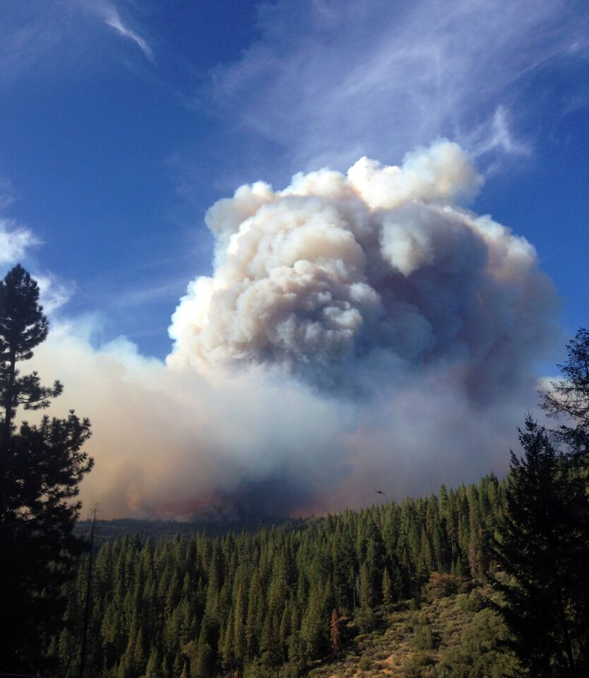 Smoke and flames loom up over the King Fire in the Eldorado National Forest.