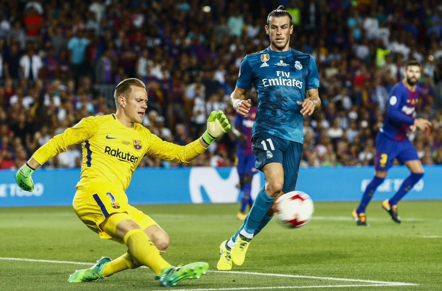 l portero alemán del FC Barcelona Marc-André Ter Stegen (i) despeja el balón junto al delantero galés Gareth Bale (d), del Real Madrid. EFE