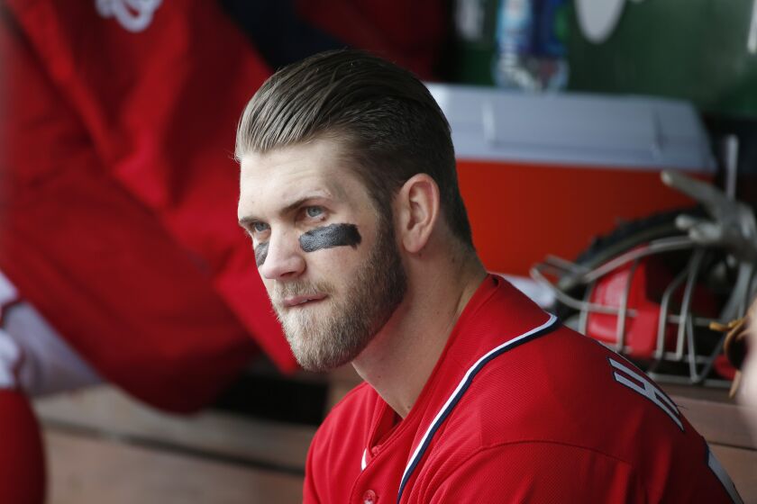Washington's Bryce Harper sits in the dugout after being pulled from Saturday's loss to the St. Louis Cardinals.