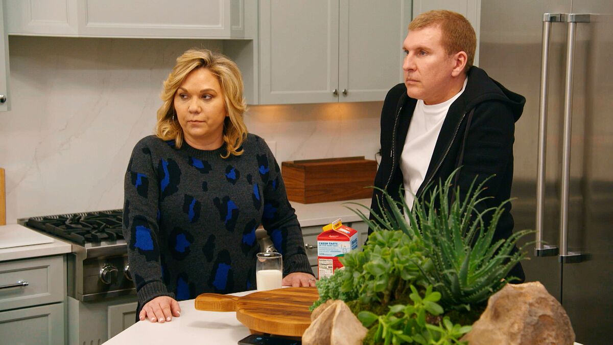 Julie and Todd Chrisley stand in a kitchen looking concerned in a scene from their reality TV show