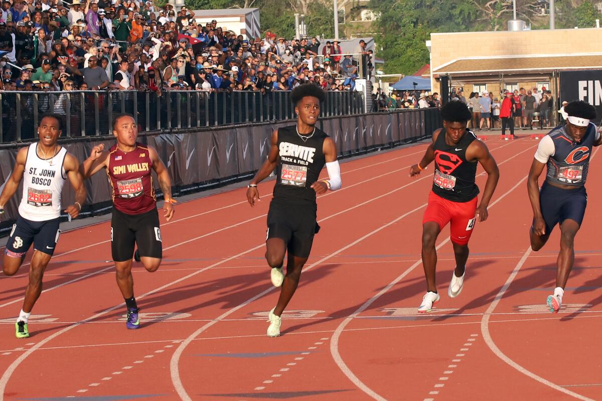 Servite's Max Thomas, center, wins the boys' 100-meter sprints in the Arcadia Invitational on Saturday.