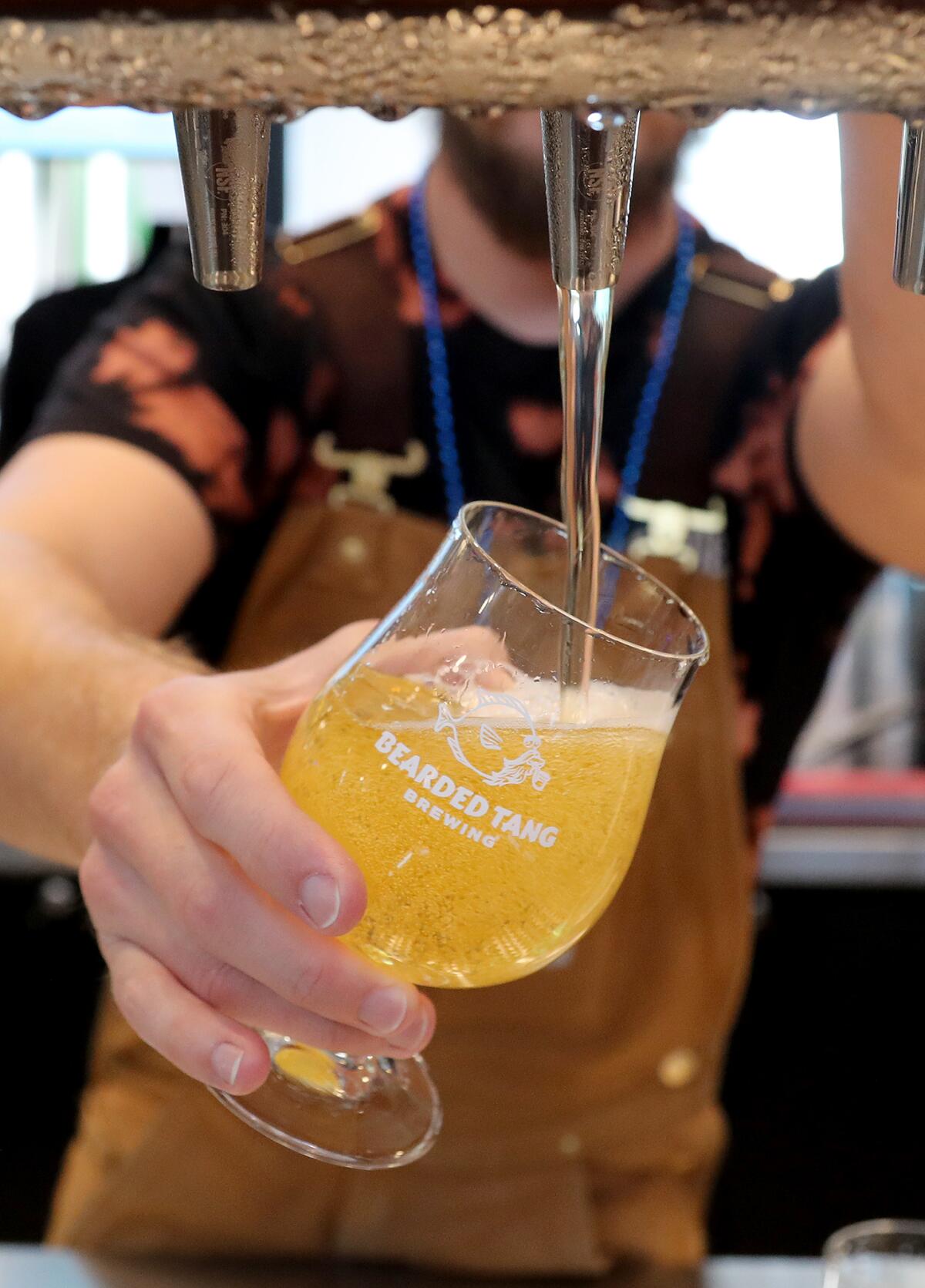 Beertender Kyle Coltrain pours a Kalamansi blonde at Bearded Tang Brewering at Rodeo 39 Public Market in Stanton.