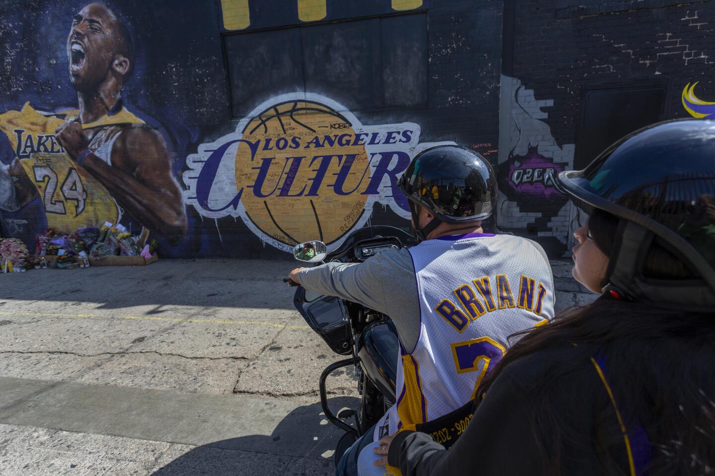 LOS ANGELES, CA - FEBRUARY 24: Fans on a motorcycle visit a mural for former Los Angeles Lakers basketball star Kobe Bryant during the official memorial ceremony for him and his daughter, Gianna, at nearby Staple Center on February 24, 2020 in Los Angeles, California. Kobe and his 13-year-old daughter who were among nine people killed in a helicopter crash on January 26 as they were flying to his Mamba Sports Academy where he was to coach her in a tournament game. (Photo by David McNew/Getty Images) ** OUTS - ELSENT, FPG, CM - OUTS * NM, PH, VA if sourced by CT, LA or MoD **