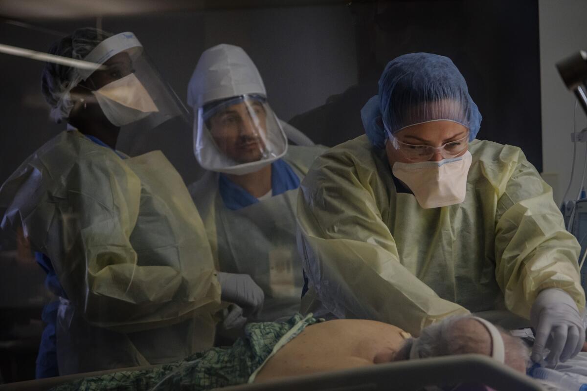 Healthcare workers administer care for an intubated patient diagnosed with COVID-19 at the Chula Vista Medical Center intensive care unit April 20.