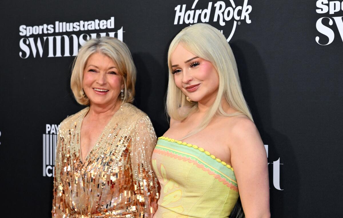 Martha Stewart and Kim Petras; behind them, a step-and-repeat banner says "Sports Illustrated swimsuit"