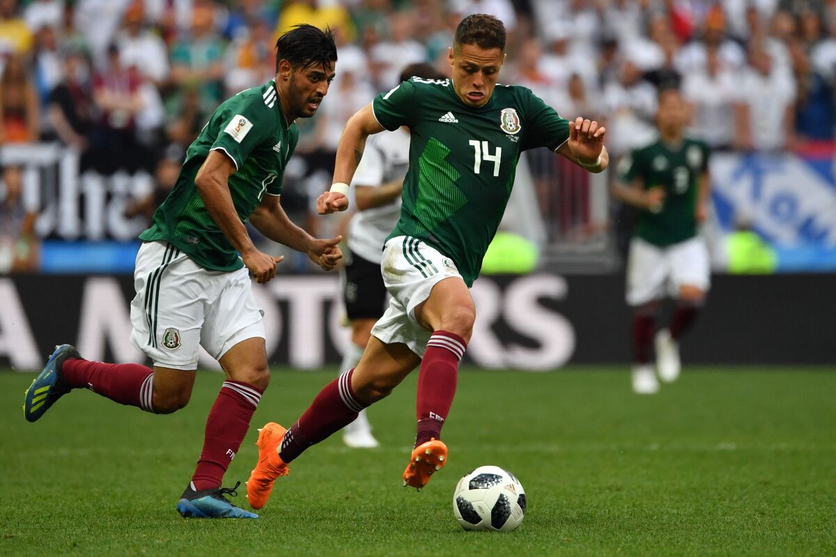Mexico's Javier "Chicharito" Hernández, right, drives the ball past forward Carlos Vela during the 2018 World Cup.