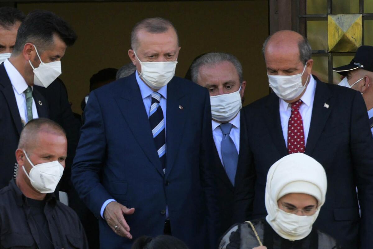 Turkish President Recep Tayyip Erdogan, center, and Turkish Cypriot leader Ersin Tatar, right, leave after their meeting in the Turkish occupied area at north part of divided capital Nicosia, Cyprus, on Monday, July 19, 2021. Speaking after Eid al-Adha prayers in northern Cyprus, President Recep Tayyip Erdogan said his country will talk with the Taliban regarding Turkey’s bid to operate and secure the airport in the Afghan capital, Kabul. (AP Photo/Nedim Enginsoy)