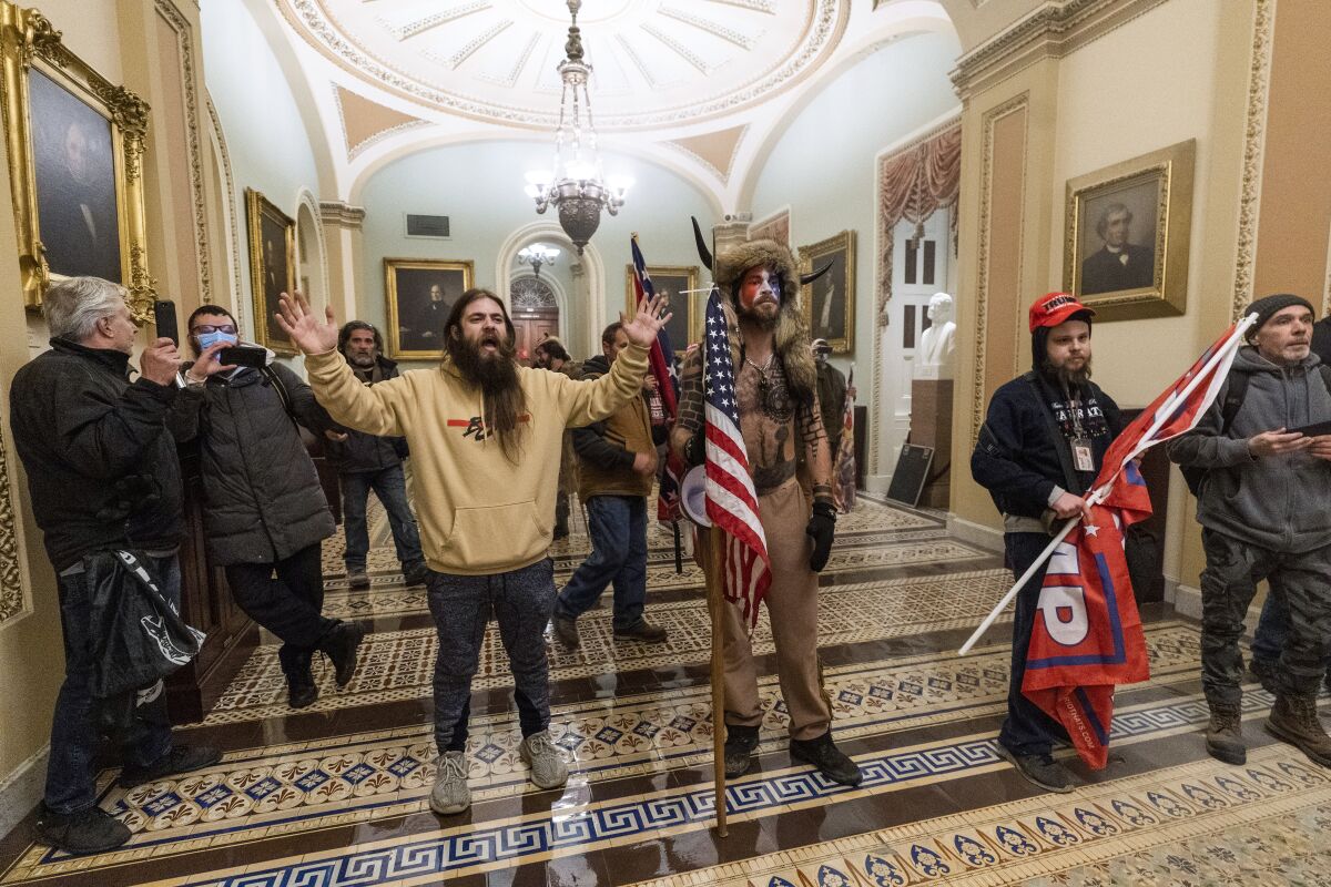 FILE - In this Jan. 6, 2021, file photo, supporters of President Donald Trump are confronted by U.S. Capitol Police officers outside the Senate Chamber inside the Capitol in Washington. Online supporters of President Donald Trump are scattering to smaller social media platforms, fleeing what they say is unfair treatment by Facebook, Twitter and other big tech firms looking to squelch misinformation and threats of violence. (AP Photo/Manuel Balce Ceneta, File)
