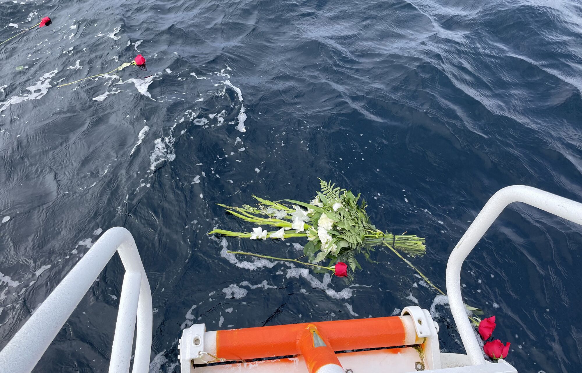 Flowers were dropped off the boat at the site of the helicopter crash.