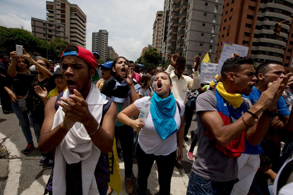 Manifestantes contra el gobierno gritan "Referendo" frente a una formación de la Policía Nacional Bolivariana que les impide marchar hacia el Consejo Nacional Electoral en Caracas, el miércoles 18 de mayo de 2016. (Foto AP/Fernando Llano)