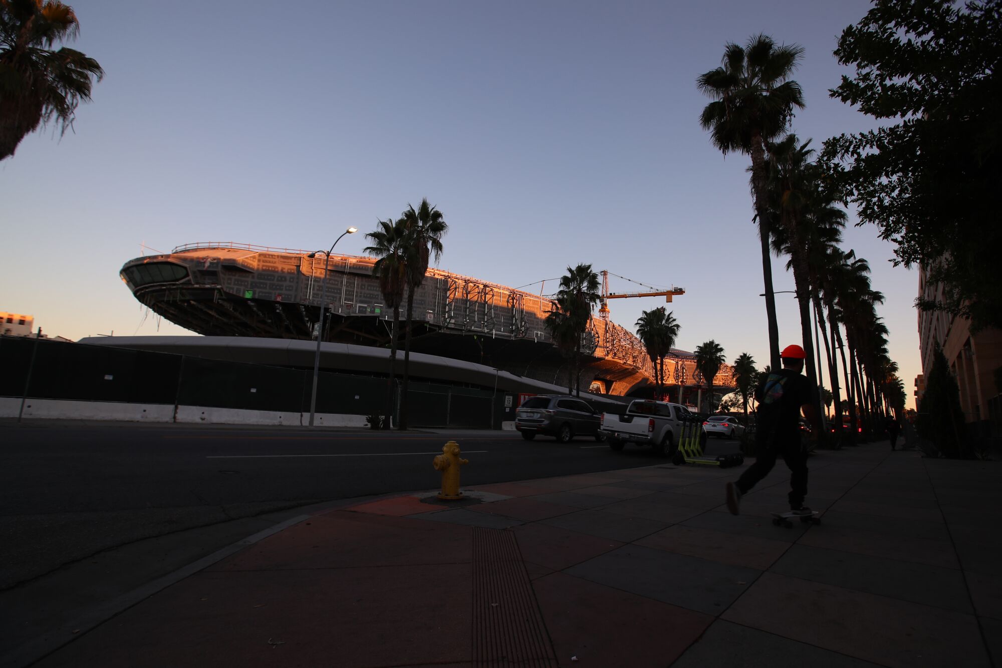 A skateboarder passes the $1-billion Lucas Museum in Exposition Park.