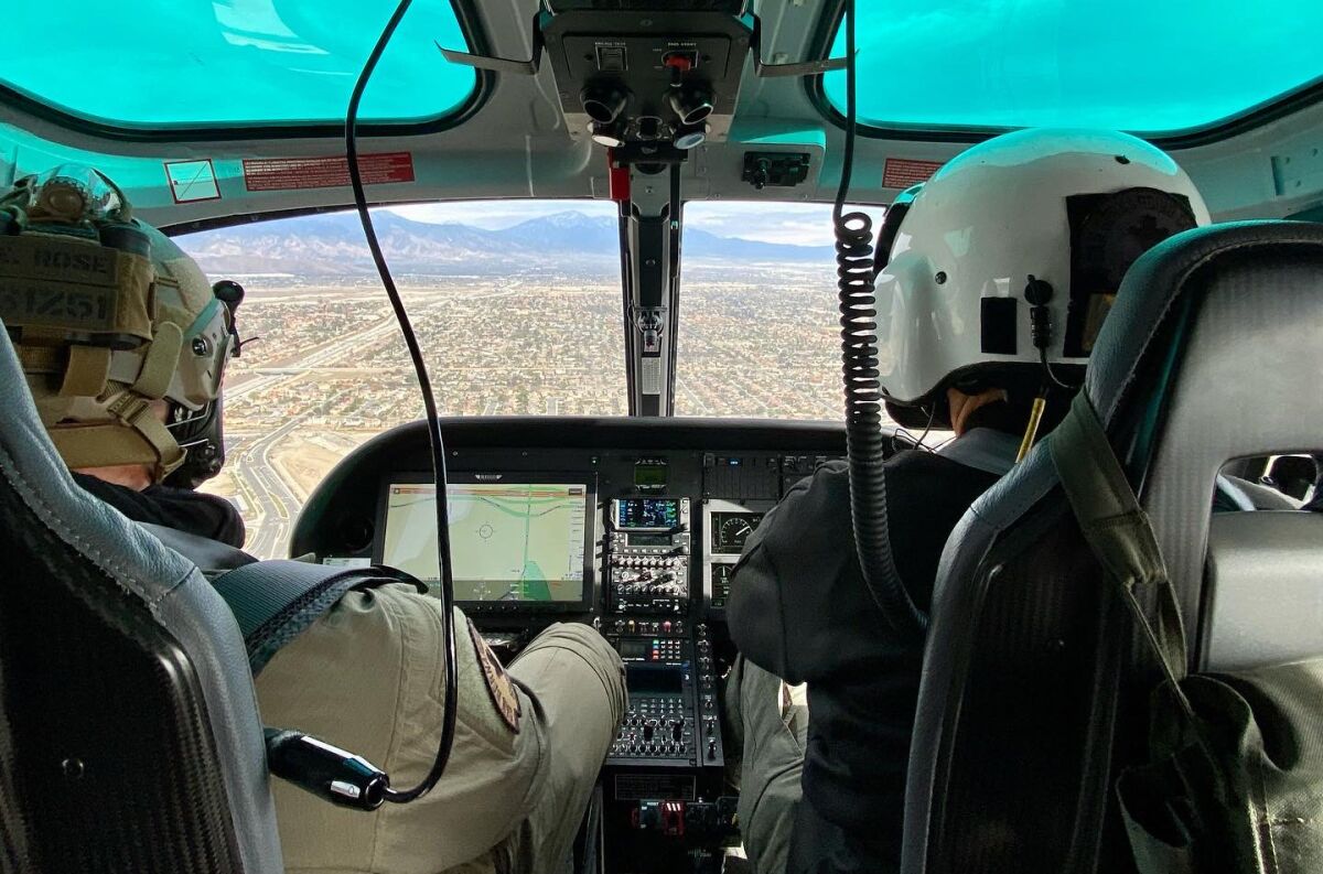 A rear view of two people flying a helicopter