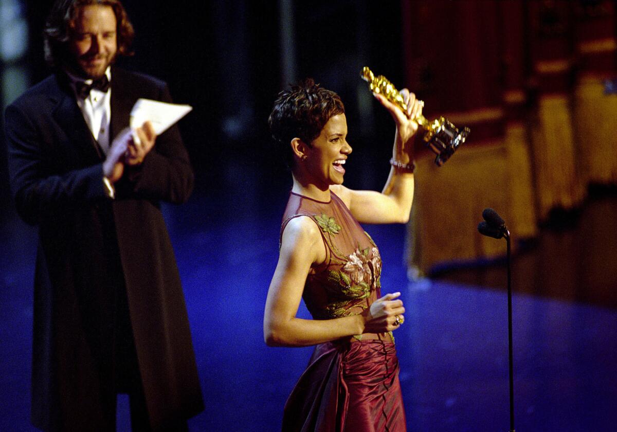 Halle Berry accepts the lead actress award for her performance in "Monster's Ball" at the 2002 Academy Awards ceremony. Russell Crowe applauds. (AMPAS / Getty Images)
